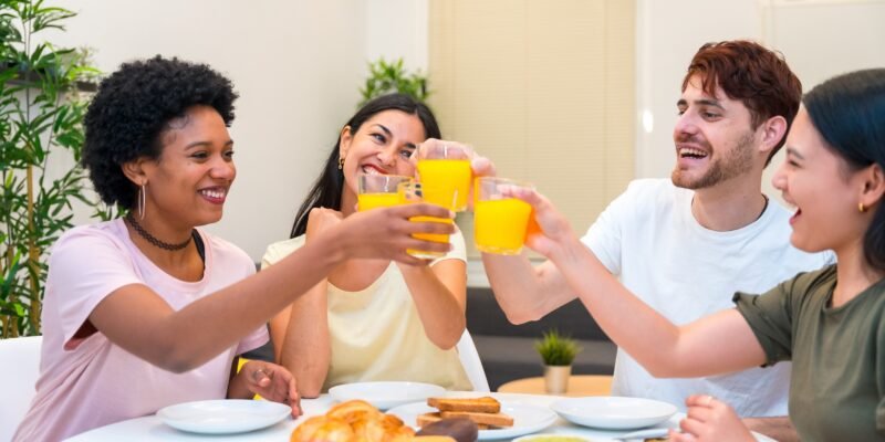Grupo de personas brindando con jugo de naranja