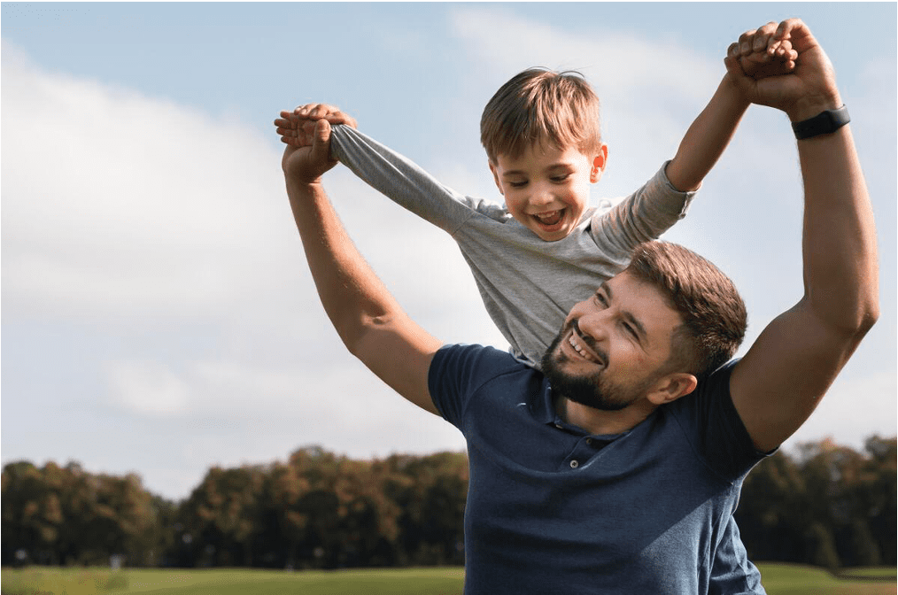 Padre levantando a su hijo en brazos en un parque