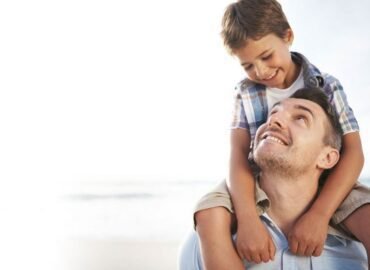 Padre cargando a su hijo sobre los hombros al aire libre