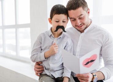 Padre con sus dos hijos sonriendo en el Día del Padre