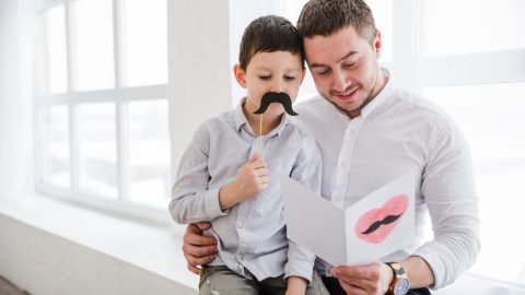 Padre con sus dos hijos sonriendo en el Día del Padre